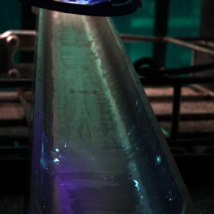 After immersion in a fluorescent dye, a component is inspected under ultraviolet light to assess the surface for imperfections.